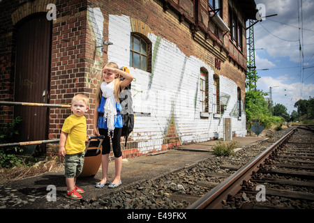 Kinder warten auf den Zug auf einem Bahnhof Stockfoto