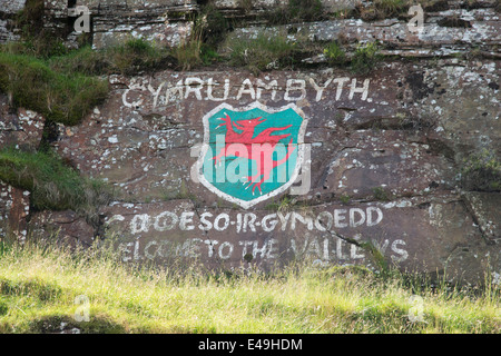 Graffiti auf den Kopf der Täler-Straße zeigt ein roter Drache und "Willkommen in den Tälern" in Walisisch, in Süd-Wales, U.K Stockfoto