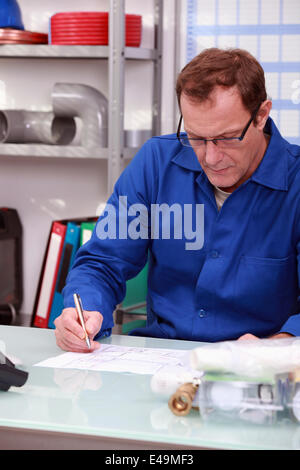 Klempner saß am Schreibtisch Stockfoto
