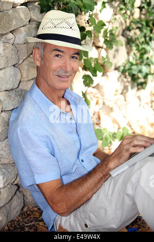 Entspannende älterer Mann in seinem Garten Stockfoto