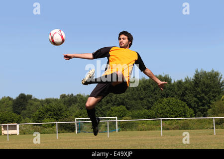 Fußballer, die den Ball in der Luft Stockfoto