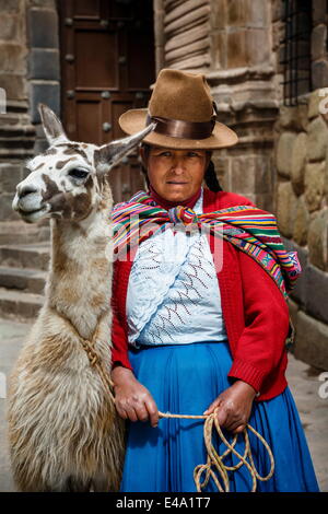 Porträt einer Frau Quechua mit Lama entlang einer Inka-Wand in San Blas Nachbarschaft, Cuzco, Peru, Südamerika Stockfoto