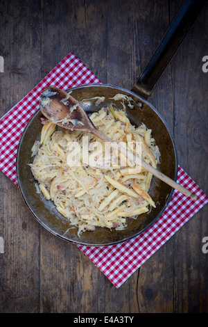 Pfanne von fingerförmige Kartoffelknödel mit Sauerkraut und Speck auf Tuch Stockfoto