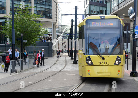 Manchester, UK. 7. Juli 2014. Metrolink Straßenbahn verläuft entlang einer Straße in Manchester in Richtung Piccadilly Station Innenstadt. Die britische Regierung hat sich verpflichtet, £ 328 Millionen in Richtung Verbesserung der Nordwestengland Verkehrsnetzes, die 12 neue Metrolink Straßenbahnen umfasst. Bildnachweis: Russell Hart / Alamy Live News. Stockfoto