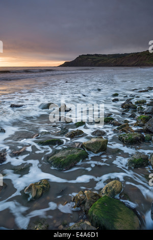 Sonnenaufgang über dem Stoupe Beck Sand in der Nähe Boggle Loch an der Küste von North Yorkshire, England Stockfoto