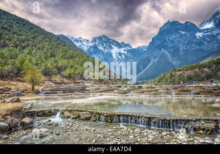 HDR-Bild des cascading fällt bei Baishuihe oder Wildwasser-Fluss mit Jade Dragon Snow Mountain, Lijiang, Yunnan, China, Asien Stockfoto