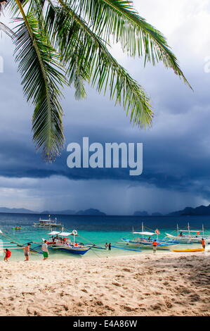 Auslegerboote vor einem Strom Verankerung an einem Sandstrand in der Bacuit Archipel, Palawan, Philippinen, Südostasien Stockfoto