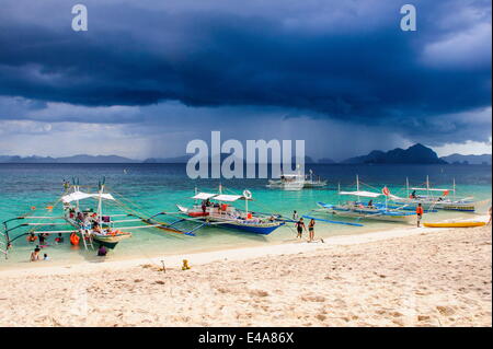 Auslegerboote vor einem Strom Verankerung an einem Sandstrand in der Bacuit Archipel, Palawan, Philippinen, Südostasien Stockfoto