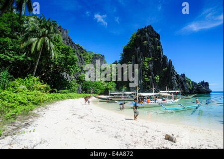 Auslegerboote auf einer sandigen Bucht im Bacuit Archipel, Palawan, Philippinen, Südostasien, Asien Stockfoto