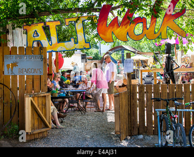 Besucher genießen Food & Drink an Bensons Taverne & Biergarten, ein Café im Freien, während die jährliche Kleinstadt ArtWalk Festival Stockfoto