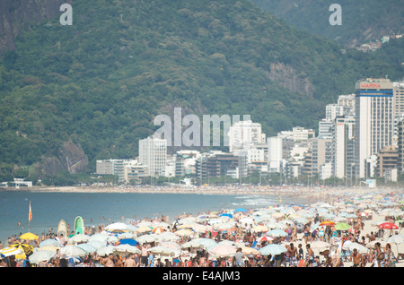 RIO DE JANEIRO, Brasilien - 1. Februar 2014: Menschen drängen sich am Strand an einem Sommermorgen in Ipanema. Stockfoto