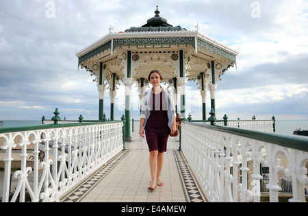 Junge Frau am Musikpavillon Brighton Seafront UK Stockfoto