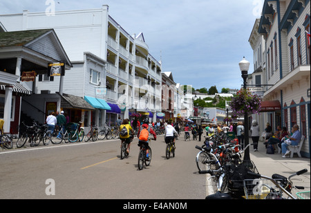 MACKINAC ISLAND, MI, USA - Juni 21: Radfahrer fahren in der Innenstadt von Mackinac Island, MI am 21. Juni 2014. Nicht angetriebene Automobile sind ein Stockfoto
