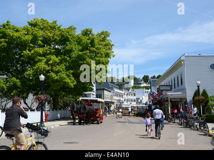 MACKINAC ISLAND, MI, USA - Juni 21: Radfahrer fahren in Richtung Innenstadt von Mackinac Island, MI am 21. Juni 2014. Nicht angetriebene Autos ein Stockfoto