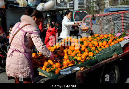 Pengzhou, China: Frau verkaufen frische lokalen Orangen von der Rückseite von ihrem Pritschenwagen am Eingang zum Pengzhou Park Stockfoto