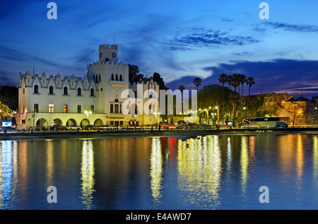 Typische Gebäude der italienischen Ära ("Residency") und die Burg Neratzia, Kos-Stadt, Insel Kos, Dodekanes, Griechenland. Stockfoto