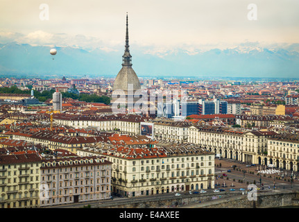 Blick auf die Stadt von Turin, Italien von Convento Monte dei Cappuccini und Blick über die Piazza Vittorio Veneto. Auf der linken Seite erhebt sich ein Luftballon in den Himmel. Zentrum ist der Turm der Mole Antonelliana. Die Alpen erheben sich im Hintergrund. Stockfoto