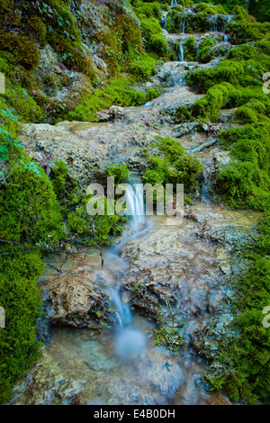 kleiner Bach bemoosten Felsen, kleinen Wasserfall im Umlauf Stockfoto