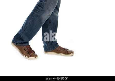 männliche Beine in Jeans und braune Sneaker Schuhe Stockfoto
