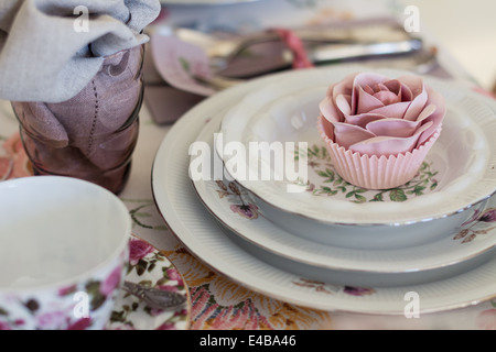 Skurrile Gedeck mit Zucker rose Cupcake auf Vintage China. Süße und romantische Details der Tea-Party-Tabelle. Stockfoto