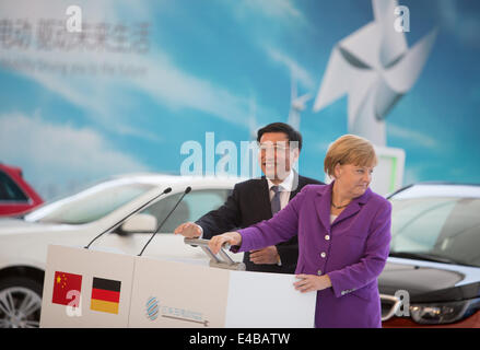 Peking, China. 8. Juli 2014. Deutsche Bundeskanzlerin Angela Merkel (CDU) und der chinesische Minister für Industrie und Information Technology Miao Wei präsentieren das Deutsch-chinesisches Kooperationsprojekt zur Schaffung einer Infrastruktur zum Laden von Elektrofahrzeugen an der Tsinghua Universität in Peking, China, 8. Juli 2014. Foto: Kay Nietfeld/Dpa/Alamy Live News Stockfoto