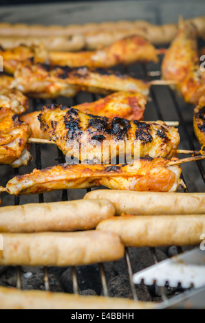 Würstchen und Chicken Wings auf das Rauchen grill barbeque Stockfoto