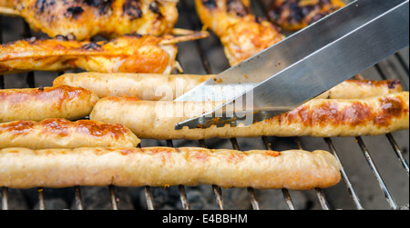 Würstchen und Chicken Wings auf das Rauchen grill barbeque Stockfoto