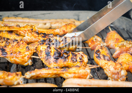Würstchen und Chicken Wings auf das Rauchen grill barbeque Stockfoto