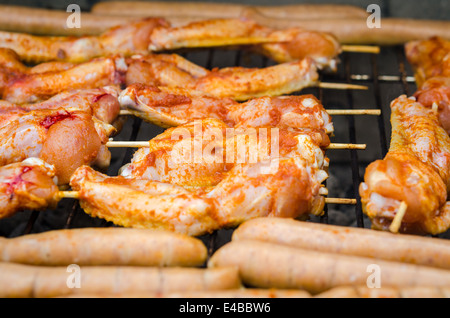 Würstchen und Chicken Wings auf das Rauchen grill barbeque Stockfoto