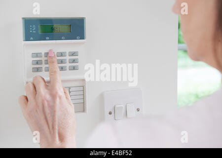 Frau Einstellung Systemsteuerung auf Home Security System Stockfoto