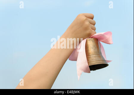 Die Hand mit einer Glocke Stockfoto