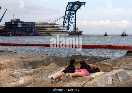 2 junge Frau, die Verlegung auf Felsen vor der Costa Concordia nach parbuckling Operationen, Insel Giglio, Toskana Italien Stockfoto