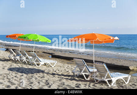 Sonnenschirm und Plank Betten am Strand Stockfoto