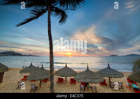 Sonnenuntergang und Palapas am Strand bei Sonnenuntergang in Mazatlan, Sinaloa, Mexiko. Stockfoto