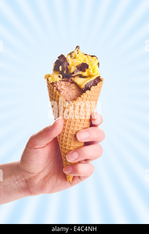 Frau Hand Holding Schokolade Eis in einem Kegel. Stockfoto