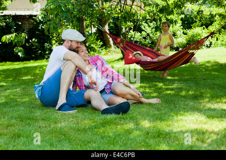 Familie mit zwei Kindern entspannend im Garten, München, Bayern, Deutschland Stockfoto