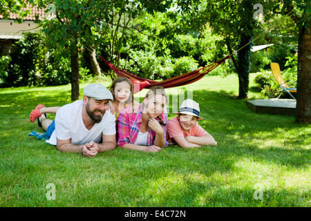 Familie mit zwei Kindern entspannend im Garten, München, Bayern, Deutschland Stockfoto