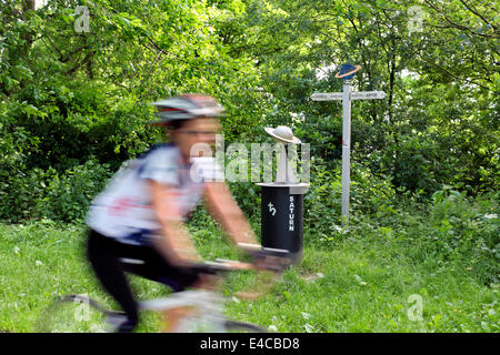 Ein Radfahrer geht ein Modell des Planeten Saturn auf der York Selby Sonnenzyklus Weg. Stockfoto