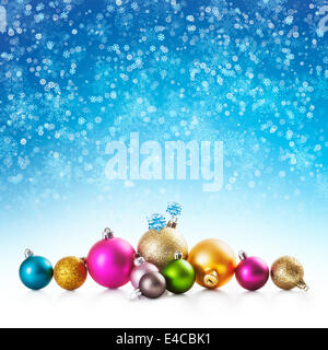 Bunte Weihnachtskugeln auf blaue Winter Hintergrund mit Schneeflocken Stockfoto