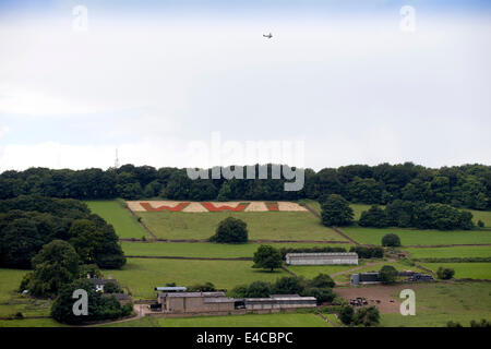 Belper, Derbyshire, UK. 8. Juli 2014.    Ein Weltkrieg zwei Tiger Moth Tipps seine Flügel in Erinnerung, wie er über ein Feld fliegt wo Mohn buchstabieren WW1 in riesigen roten Lettern mit Blick auf Belper in Derbyshire. Die riesigen 100 Fuß Buchstaben wurden von Mitgliedern der Belpers Armee-jüngstere Söhne mit 25 Millionen Mohn im Herbst letzten Jahres - eine für jeden Mann und Pferd getötet in den ersten Weltkrieg gesät. Stockfoto