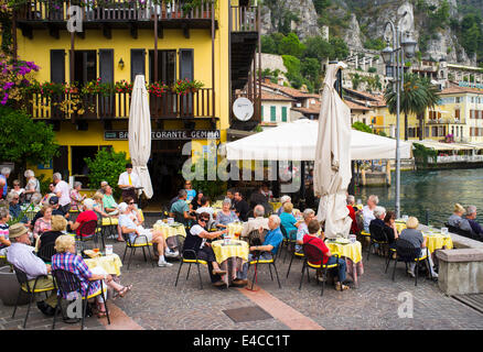 Urlauber, Essen im Freien vor einem Restaurant in der malerischen Ortschaft Limone am Ufer des Gardasee, Italien. Stockfoto