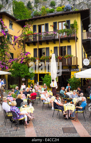 Urlauber, Essen im Freien vor einem Restaurant in der malerischen Ortschaft Limone am Ufer des Gardasee, Italien. Stockfoto