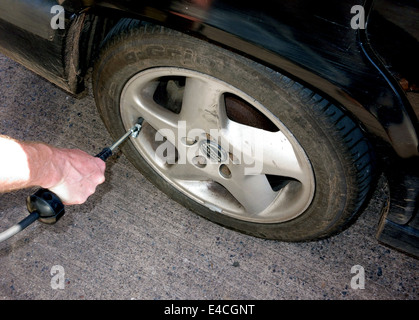 Autofahrer überprüft Reifendruck an Tankstelle, Somerset, England Stockfoto