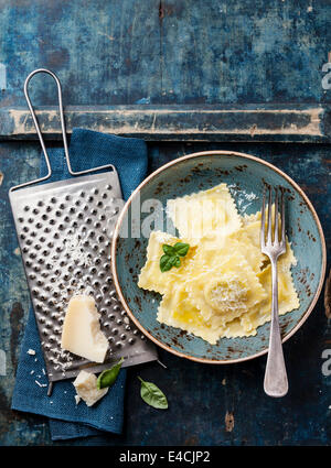 Ravioli Pasta mit Mozzarella, Basilikum und Parmesan auf blauem Hintergrund Stockfoto