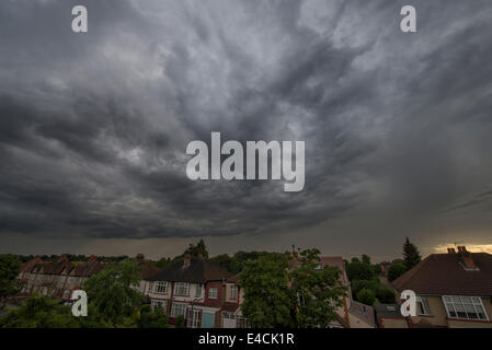 Wimbledon, London, UK. 8. Juli 2014. Eine große Masse von Regenwolke geht über den südlichen Vorort von London in der Abenddämmerung nach einem Nachmittag Gewitter in Teilen von Surrey. Bildnachweis: Malcolm Park Leitartikel/Alamy Live-Nachrichten Stockfoto