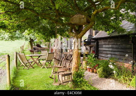 Holzmöbel und Schaukel im Garten des Landhaus Stockfoto