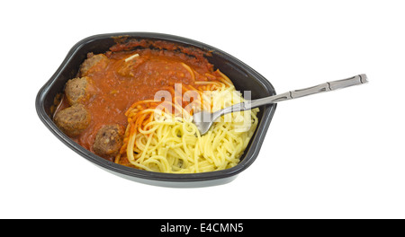 Ein Essen aus der Mikrowelle Spaghetti und Fleischbällchen TV Dinner in einer schwarzen Schale mit einer Gabel in die Nudeln auf einem weißen Hintergrund eingefügt. Stockfoto