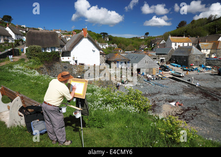 Ein Künstler tragen ein Trilby malt eine Outdoor-Strand-Szene mit einer Staffelei. Stockfoto