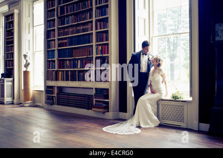 Hochzeitsvorbereitungen, Braut und Bräutigam in Bibliothek, Dorset, England Stockfoto