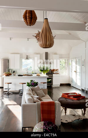 Weiße offene Wohnraum mit Holzfurnier Beleuchtung, Ikea Küche Einheiten und moderne Creme sofa Stockfoto